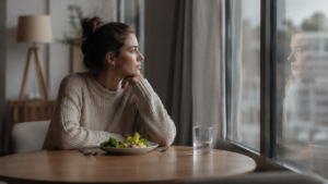 Pessoa refletindo sobre sua relação com a comida e o corpo, representando os transtornos alimentares e o sofrimento emocional.